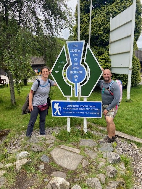 Erin and Scott beside the sign marking the end of the West Highland Way